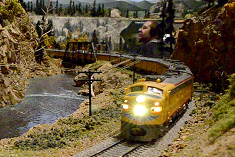 Colorado Model Train display - a train runs on tracks along a river